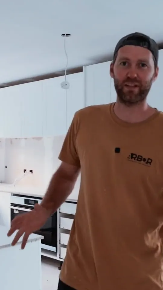 Arbor Building's builder speaking to camera in a renovated room
